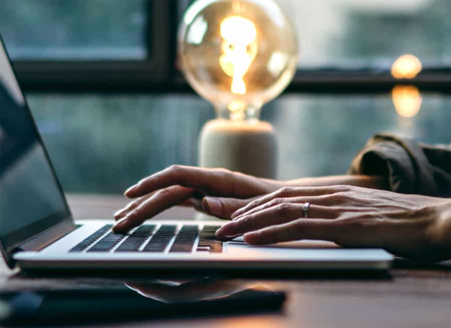 Hands typing on laptop keyboard