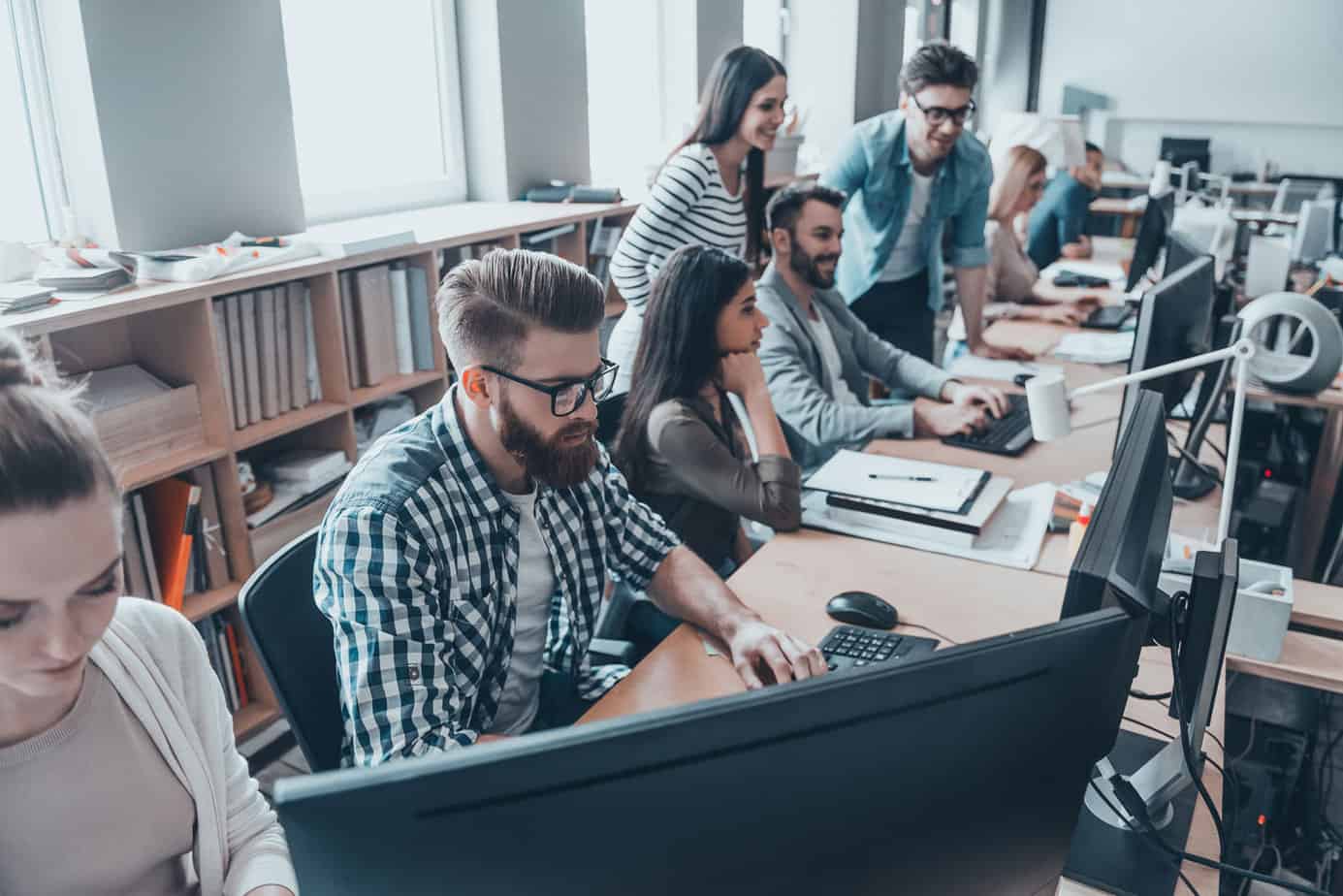 Group of people working at computers in office