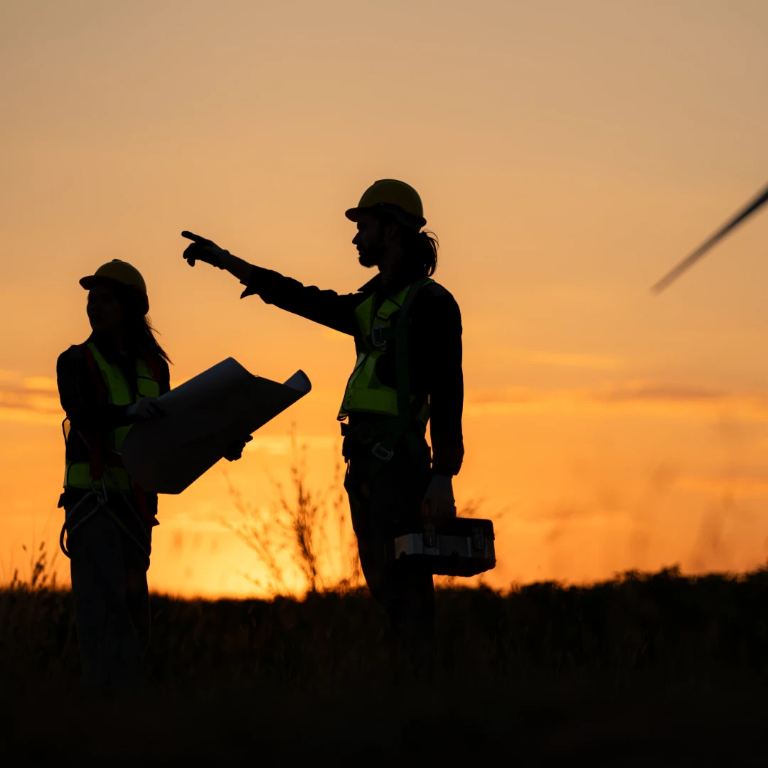 Silhouette of Engineer in charge of wind energy against a background of wind turbines