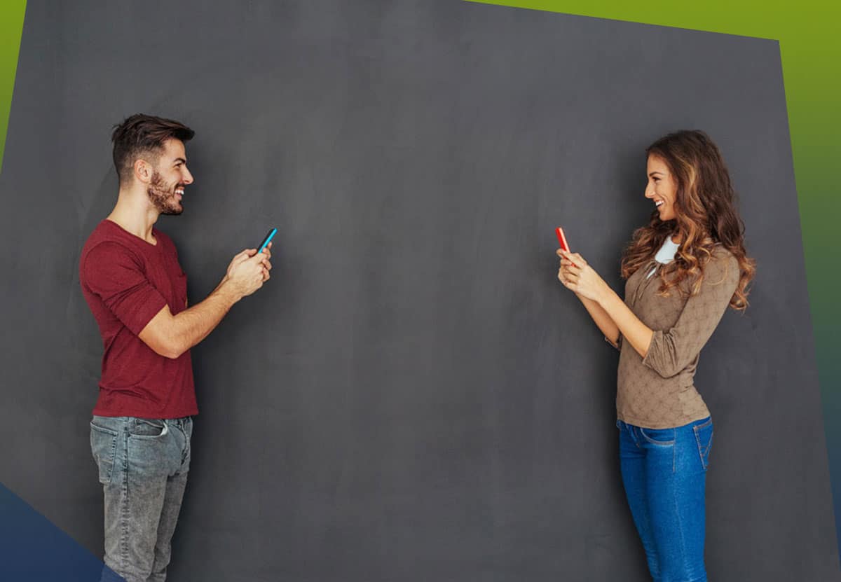 Man and woman standing apart on mobile phones