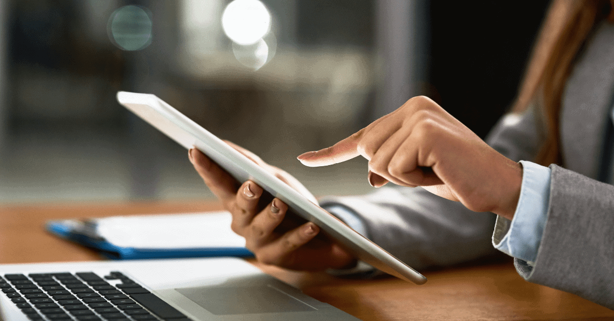 person on their mobile phone with laptop nearby