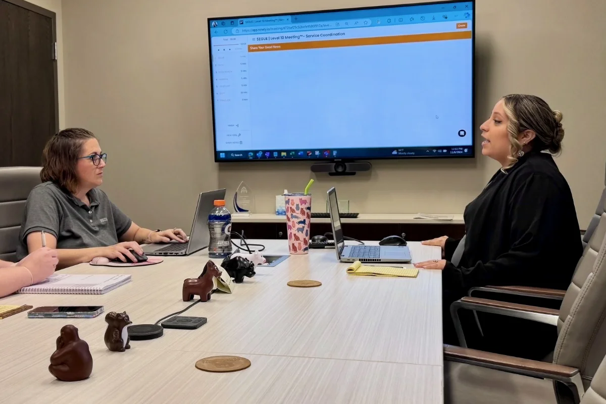 Colleagues working at meeting room desk in modern office
